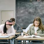 students sitting by the table in the classroom